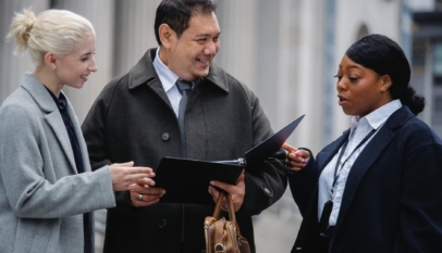 content diverse colleagues reading documents and discussing project on street