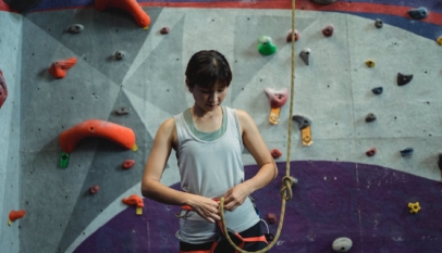 focused ethnic female climber preparing for climbing training