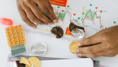 person holding chocolate coins on white paper