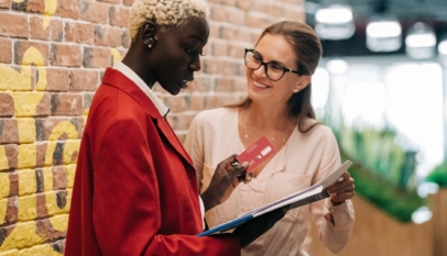 multiethnic businesswomen discussing payment with credit card